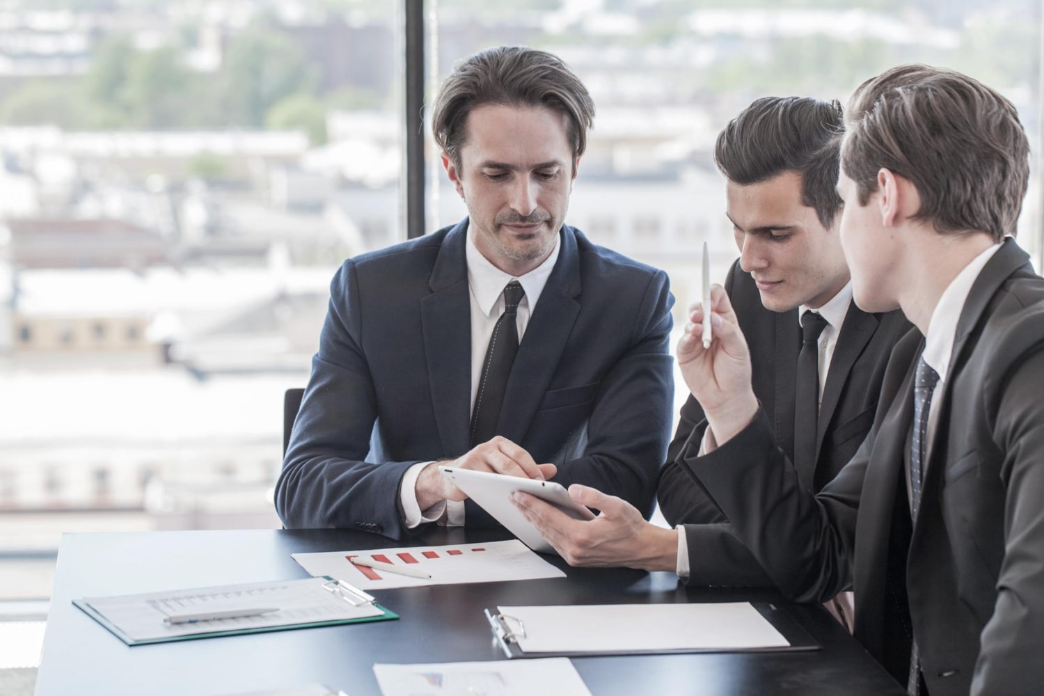 Businessmen Collaborating Using Tablet In Office Setting