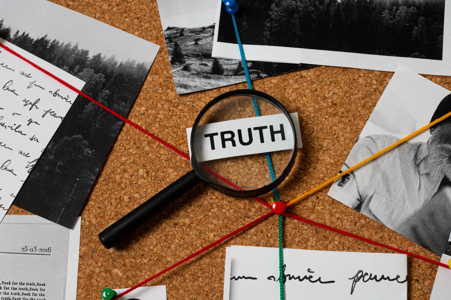 Magnifying Glass Revealing The Word Truth On Corkboard