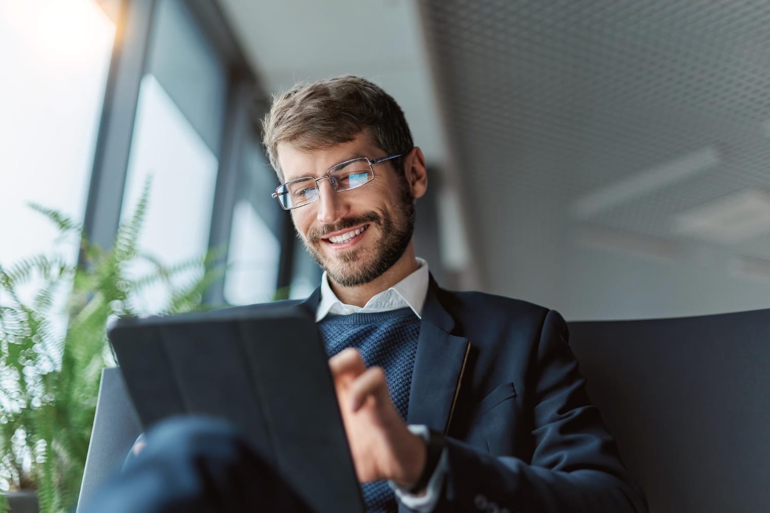 Smiling Businessman Using Digital Tablet In Modern Office