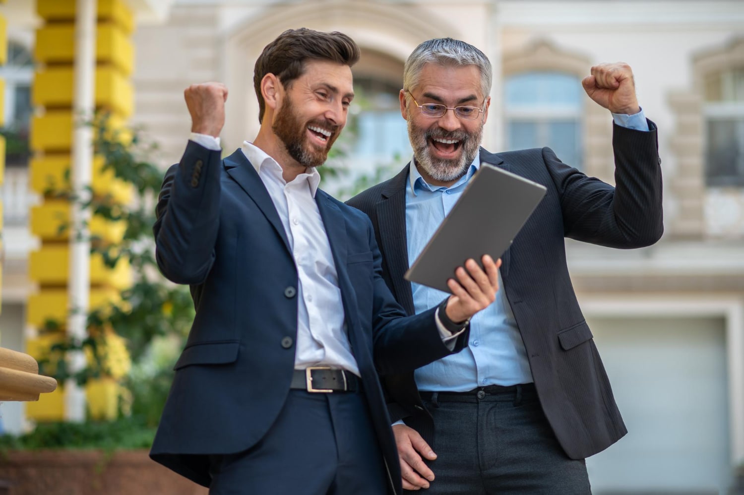 Two Businessmen Celebrating Success With Digital Tablet