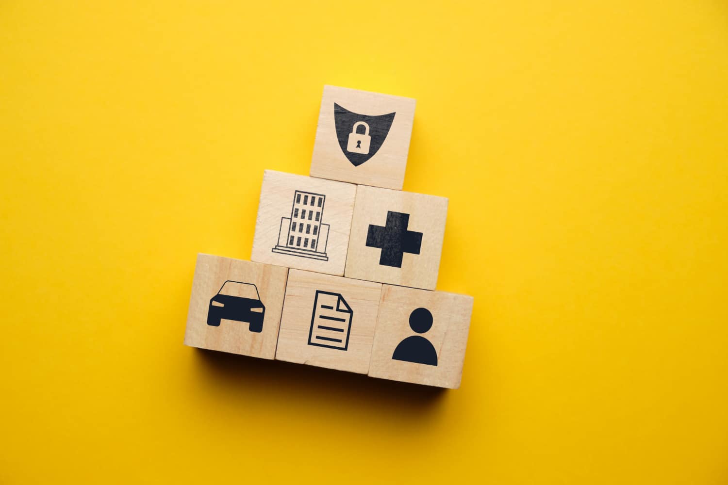 Insurance Icons On Yellow Background On Wooden Blocks